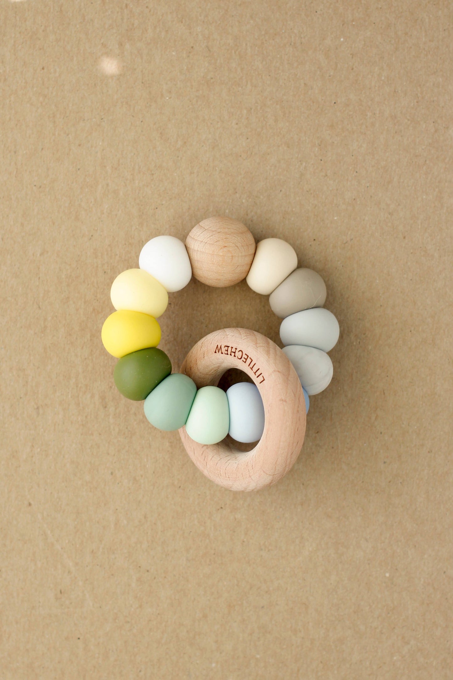 Colorful baby teething ring on a brown background
